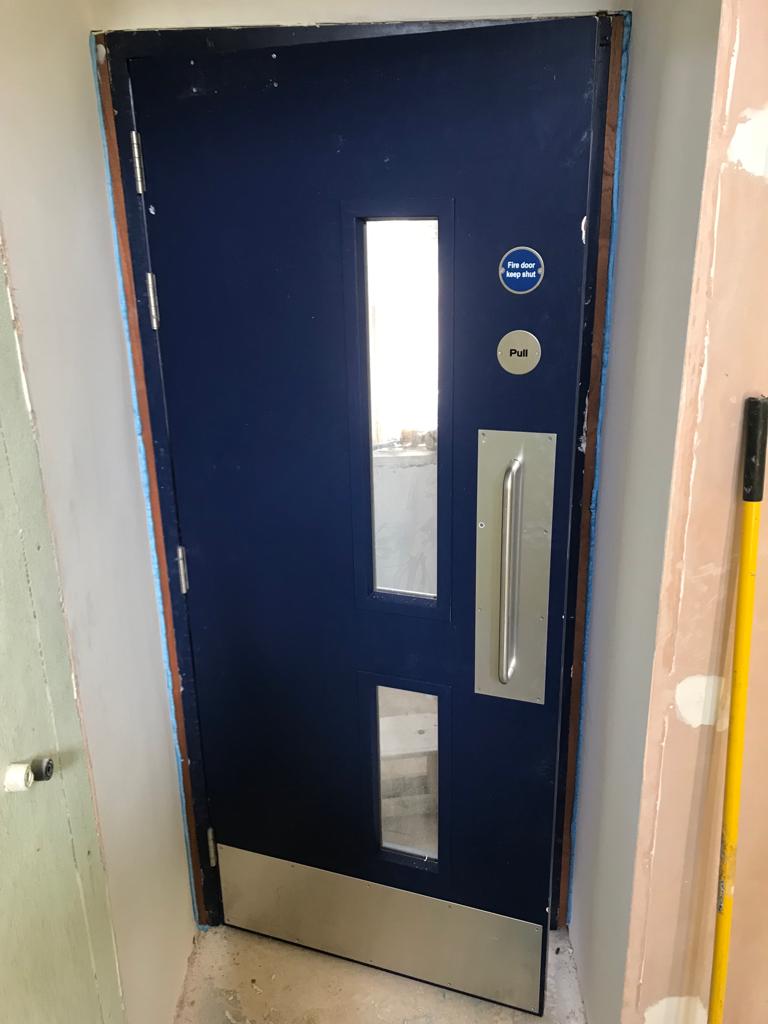 Navy blue fire door with push plate